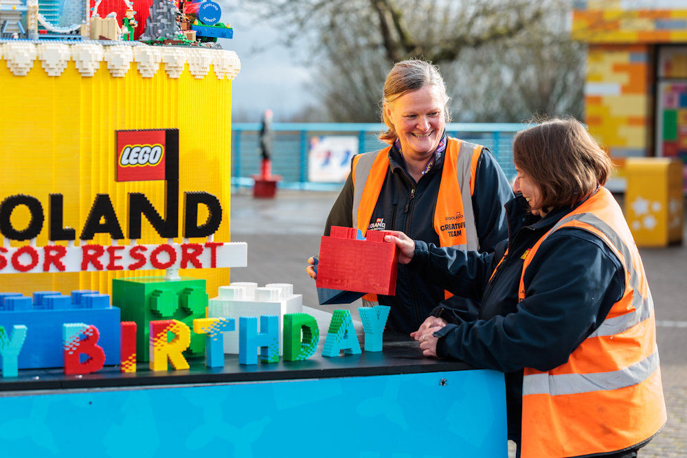 Model makers standing next to Legoland 30th birthday cake